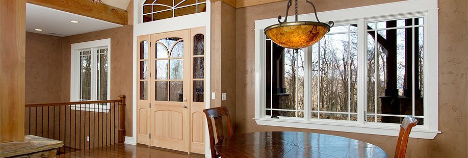 A dining room with a table and chairs and a chandelier hanging from the ceiling.