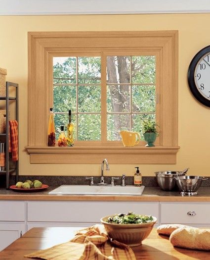 A kitchen with a large window and a clock on the wall