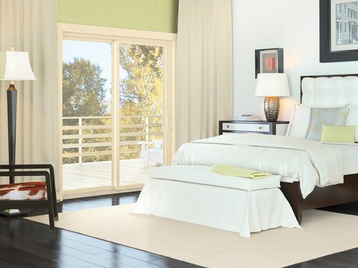 A bedroom with a sliding glass door leading to a balcony