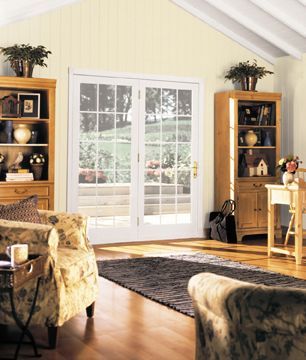 A living room with a vaulted ceiling and sliding glass doors