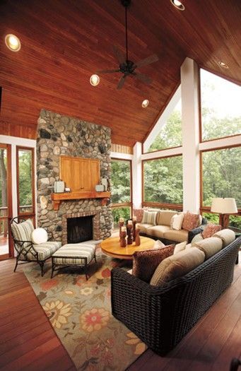 A living room with a fireplace and lots of windows