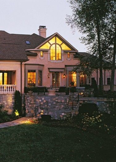 A large house with a lot of windows is lit up at night