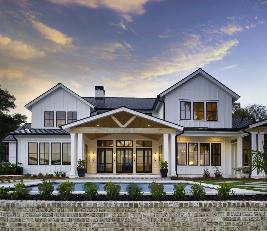 A large white house with a swimming pool in front of it