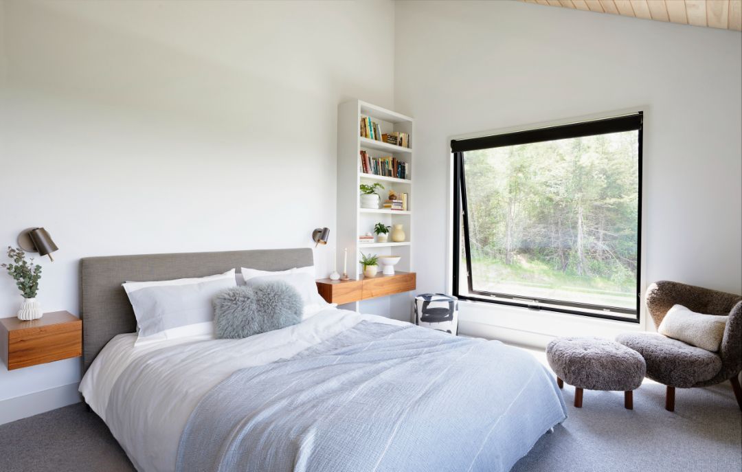 A bedroom with a large bed and a large window.
