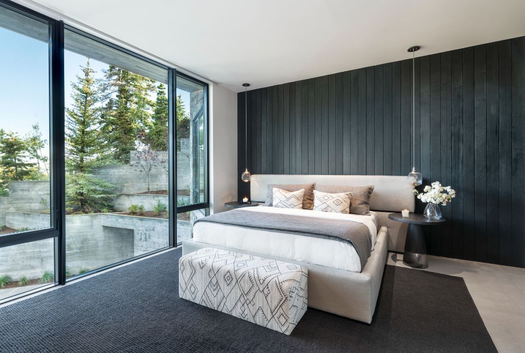 A bedroom with a large bed and lots of windows.