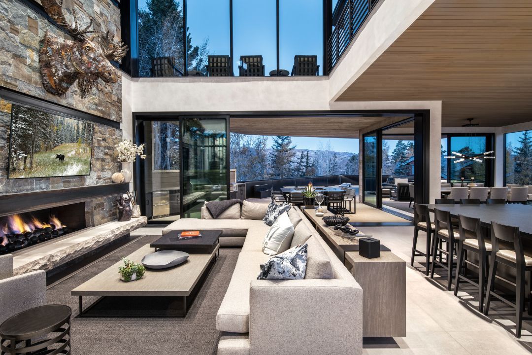 A living room with a couch , fireplace , table and chairs.