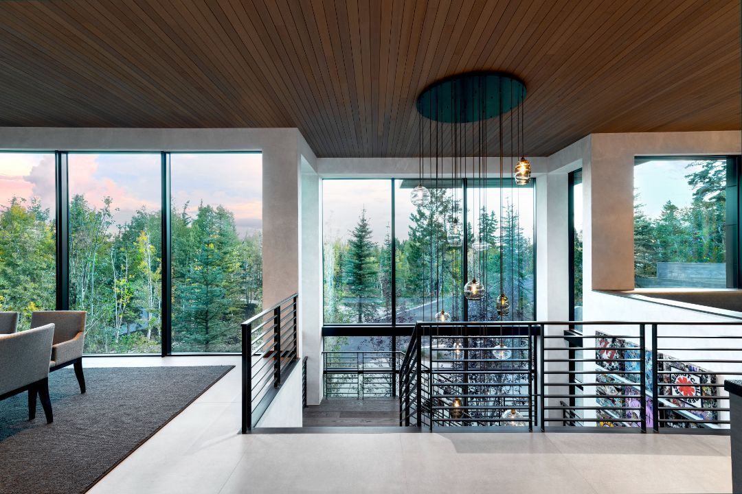 A living room with a lot of windows and a staircase
