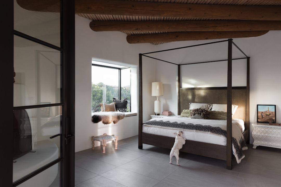 A bedroom with a canopy bed and a window