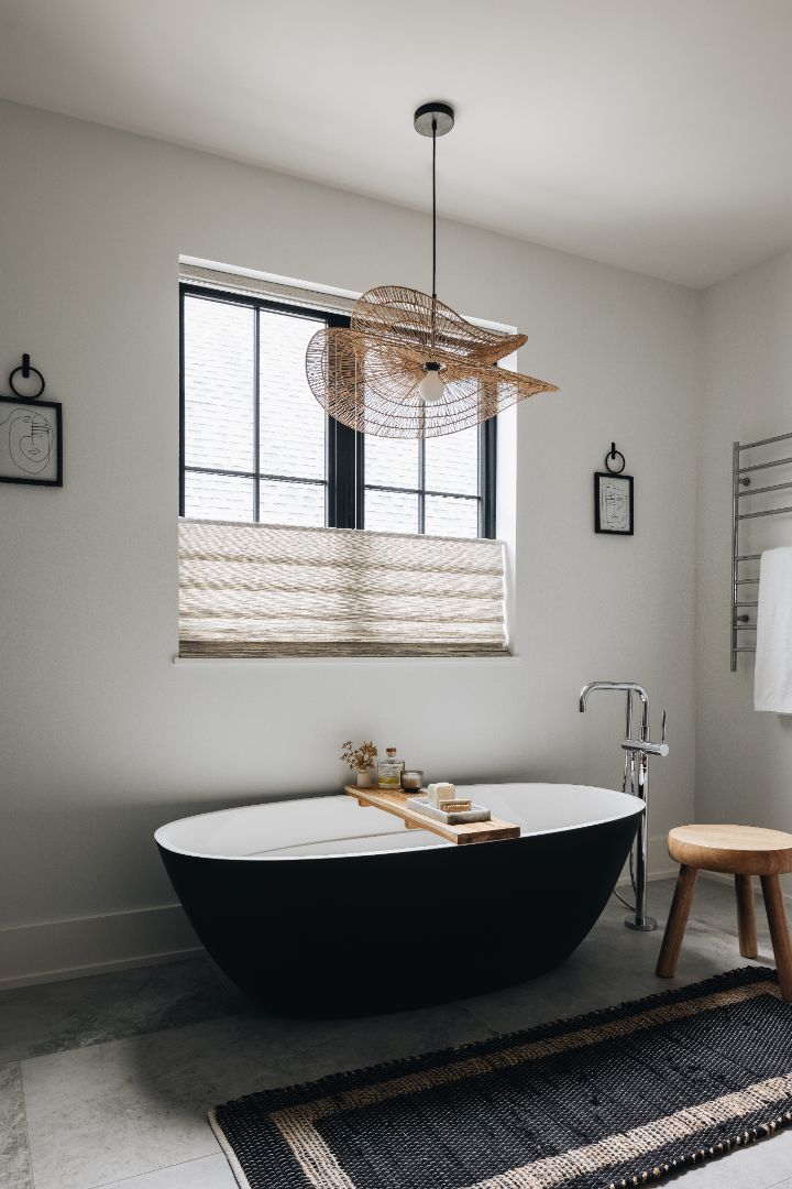 A bathroom with a black tub and a fan hanging from the ceiling.