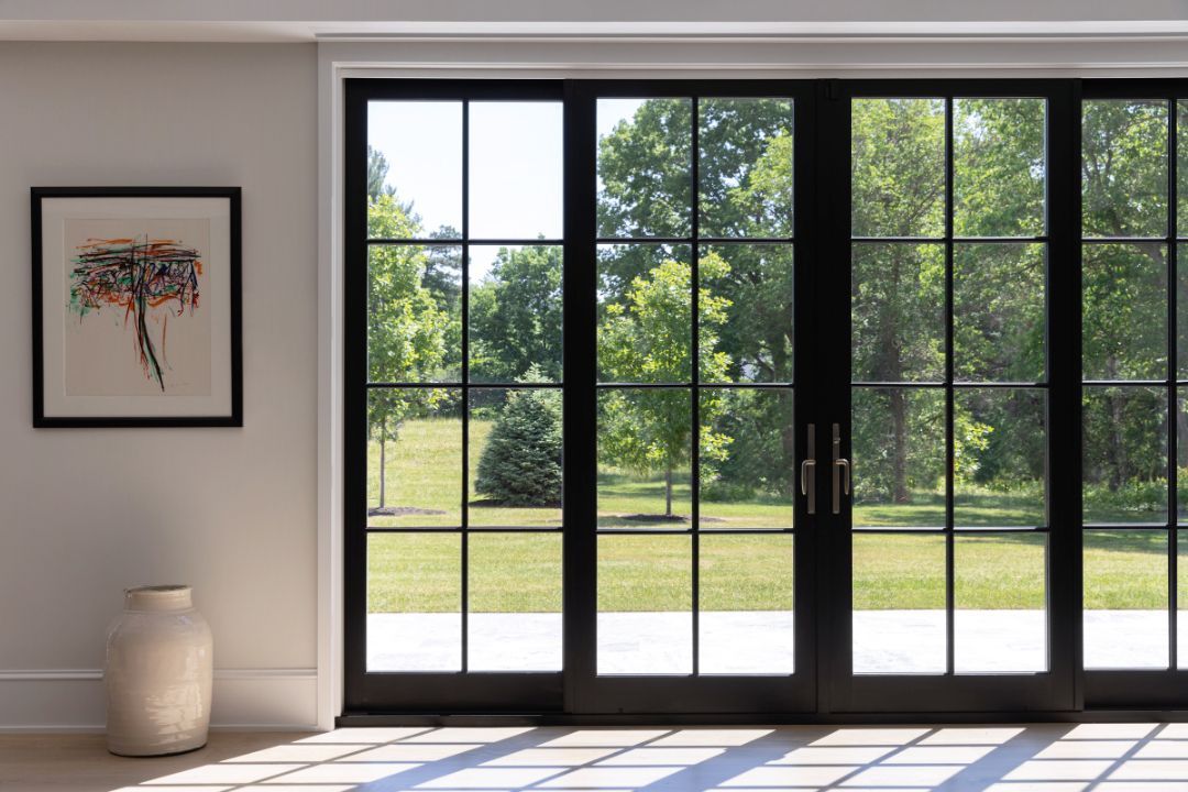 A room with a lot of windows and a picture on the wall.