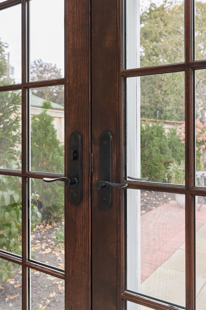 A close up of a wooden door with a twisted handle.