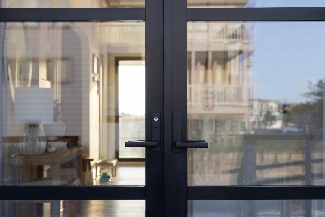 A close up of a glass door leading to a living room.