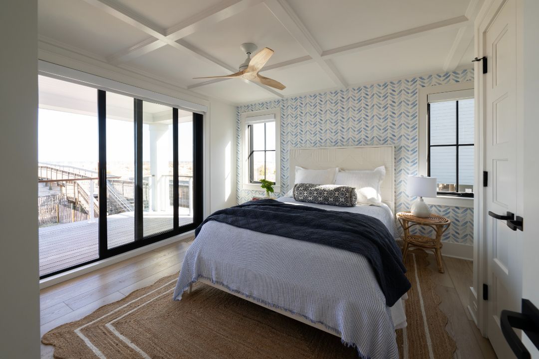 A bedroom with a large bed and a ceiling fan.