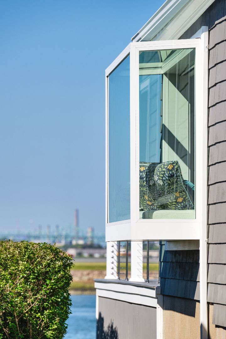 A house with a balcony overlooking a body of water.