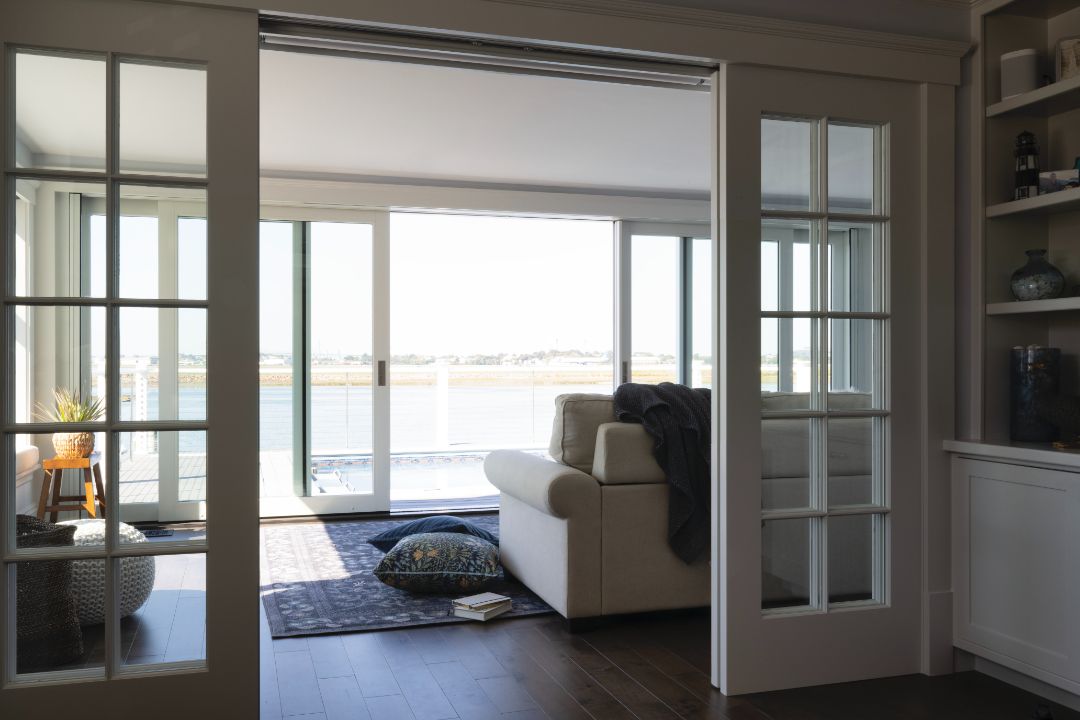 A living room with a white couch and sliding glass doors