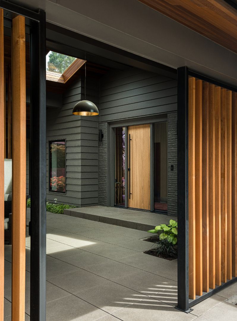 A house with a wooden door and a wooden fence in front of it.