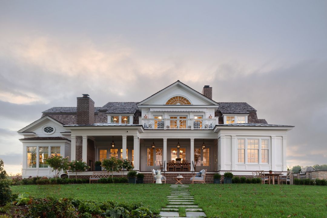 A large white house with a lush green lawn in front of it