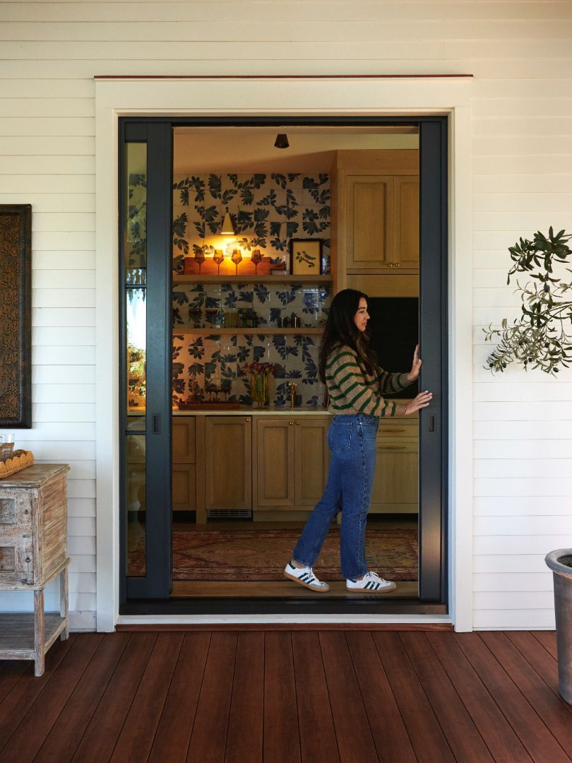 A woman standing in front of a sliding glass door