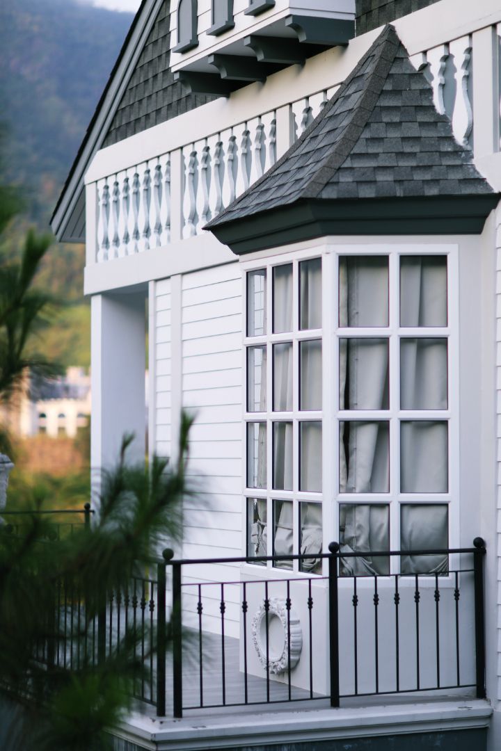 A white house with a balcony and a black railing