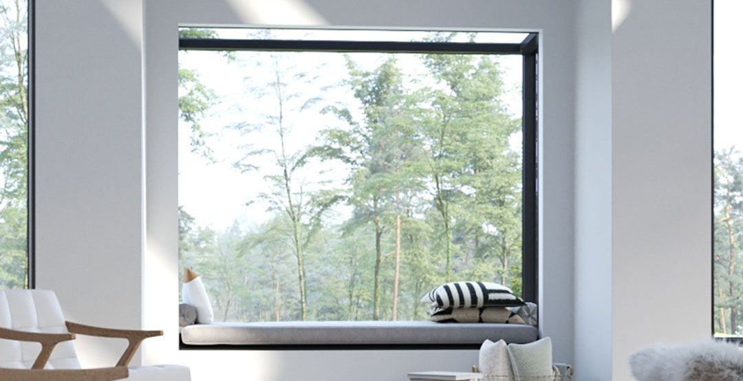 A living room with a large window looking out to a forest.