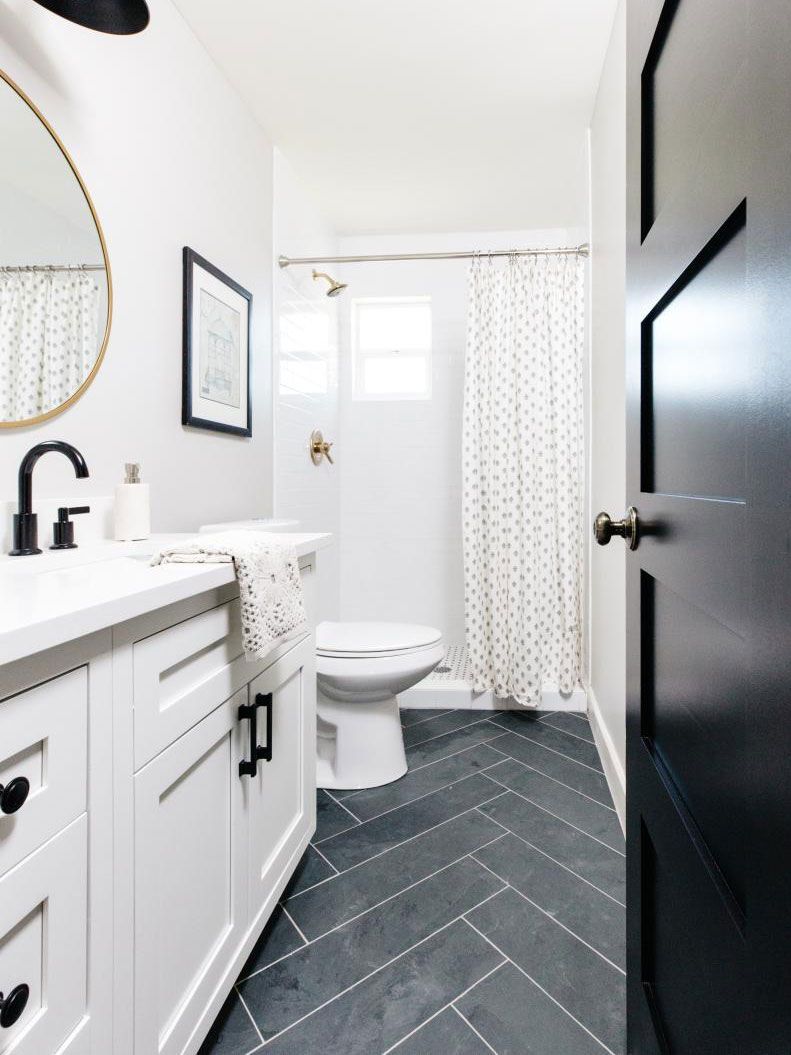 A bathroom with a toilet , sink , mirror and shower curtain