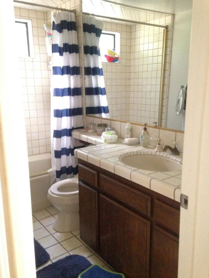 A bathroom with a toilet a sink and a shower curtain