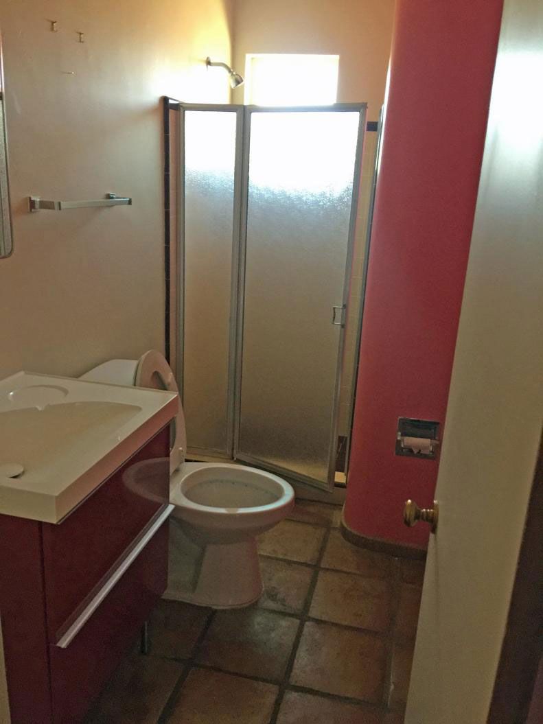 A bathroom with a toilet a sink and a shower