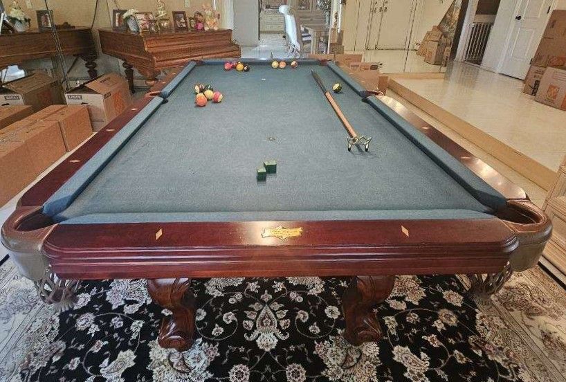 A pool table with balls and cues on it