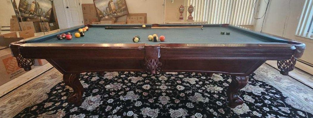 A pool table is sitting on top of a rug in a living room.