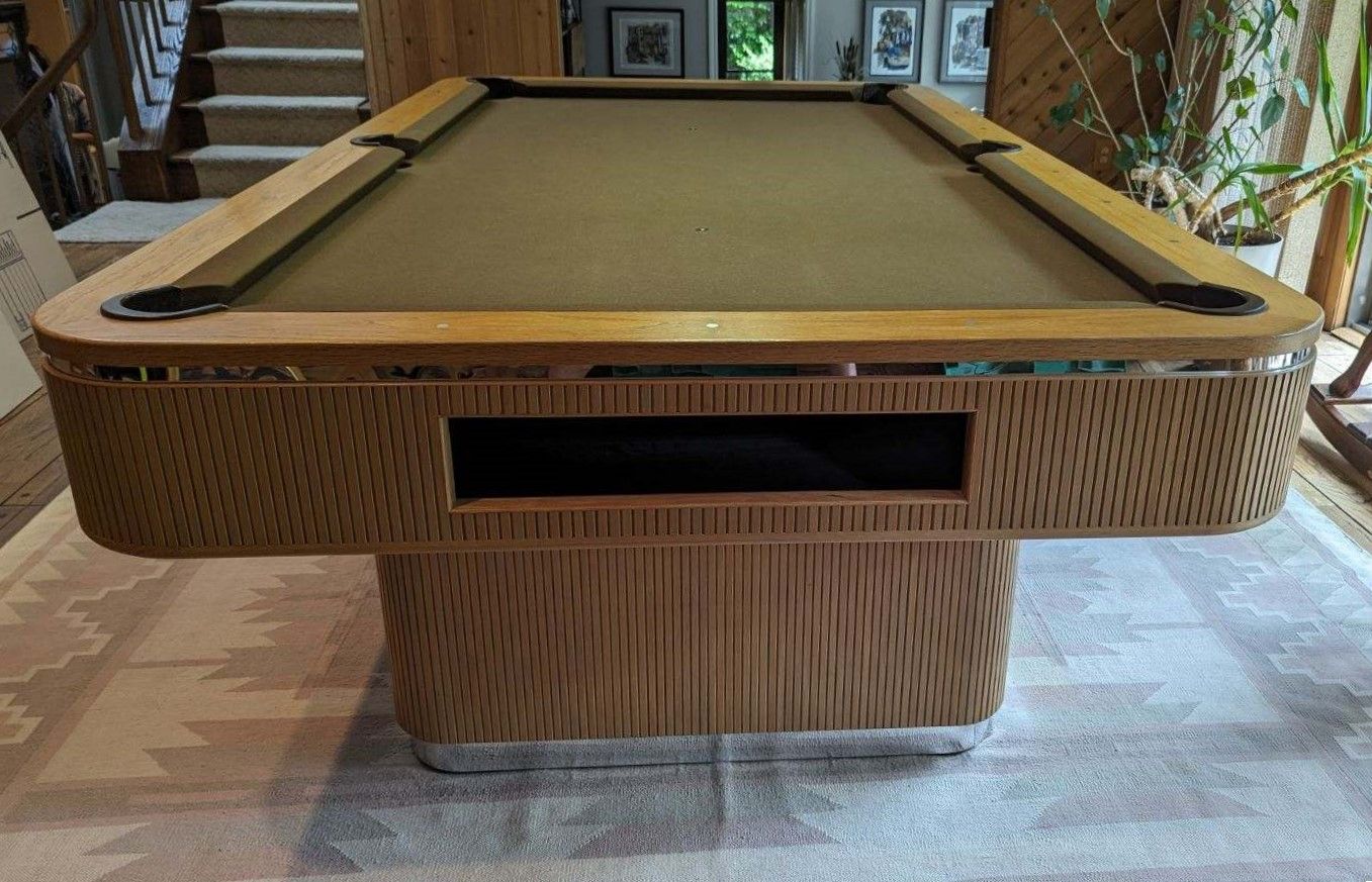 A pool table with a bag on it that says ' coast ' on it