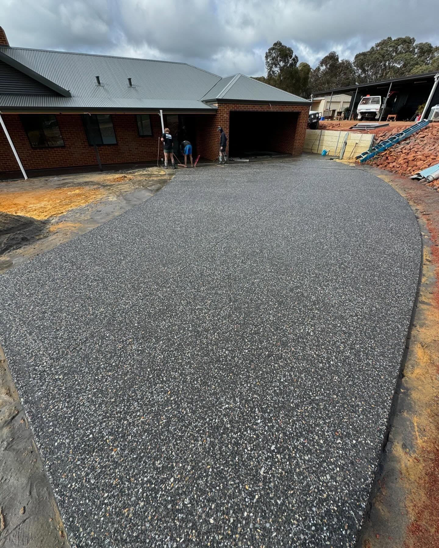 Large exposed aggregate driveway leading to a house in Perth