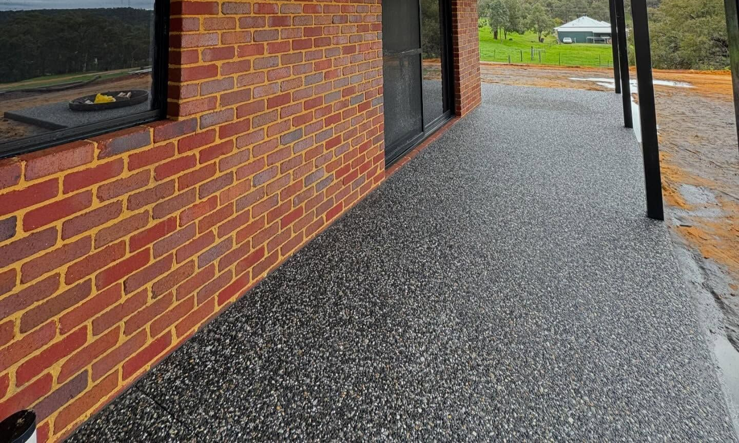 Exposed aggregate pathway on rural property wrapping around the house from the patio.