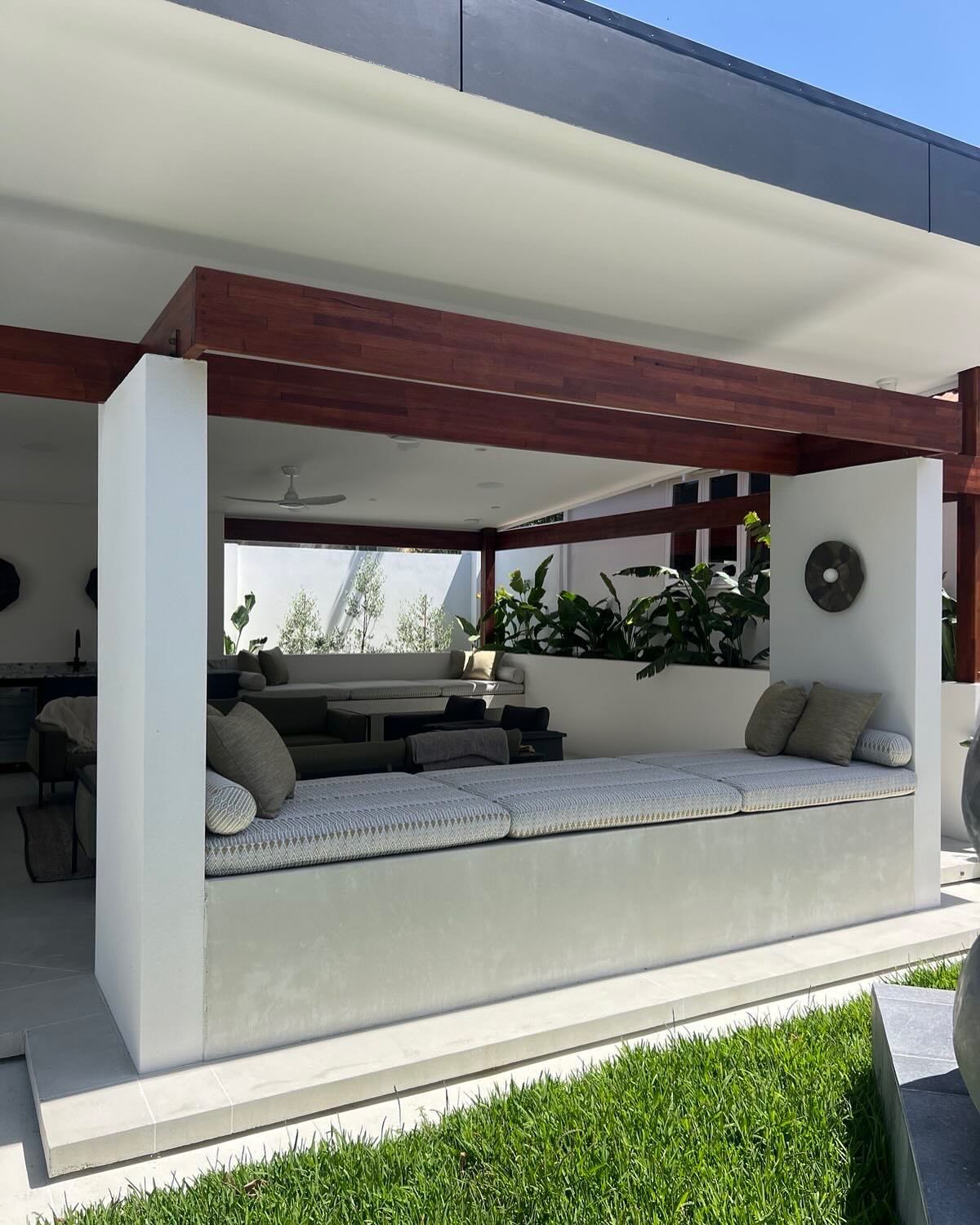 Concrete alfresco with day bed and outdoor seating with kitchen