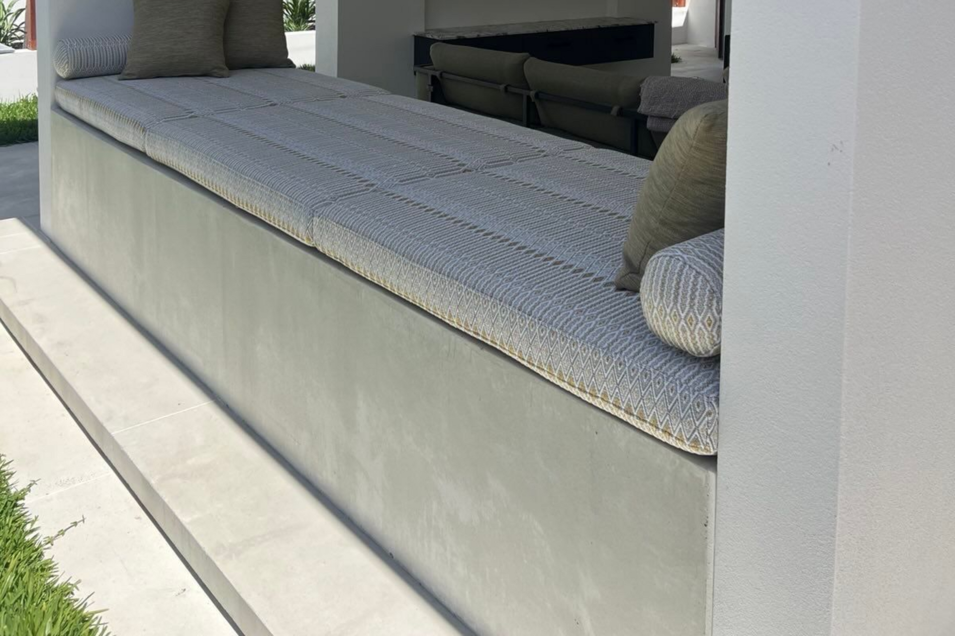 Charcoal exposed aggregate concrete driveway and step into front door