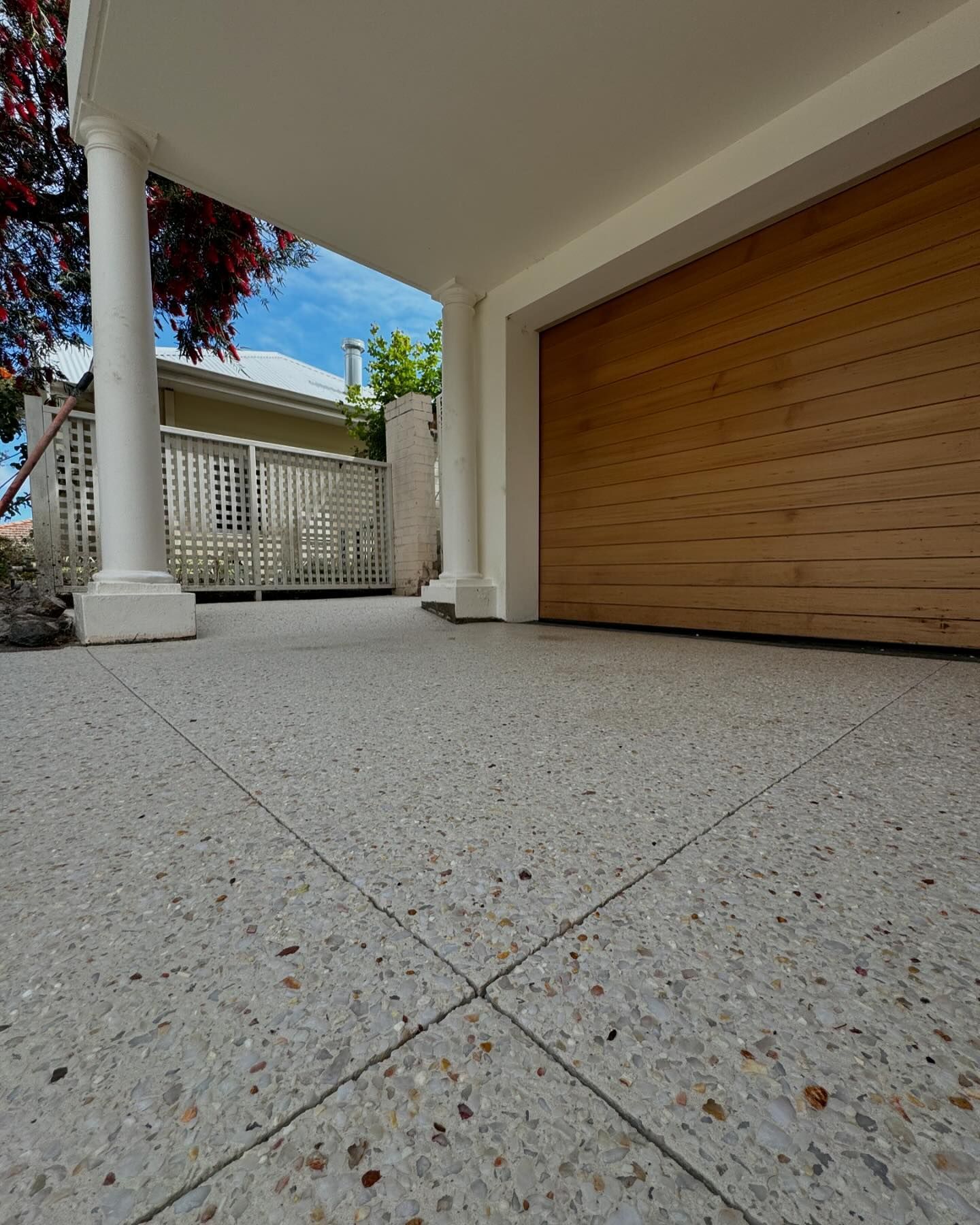 Coral White exposed aggregate driveway with pillar and roller door for garage