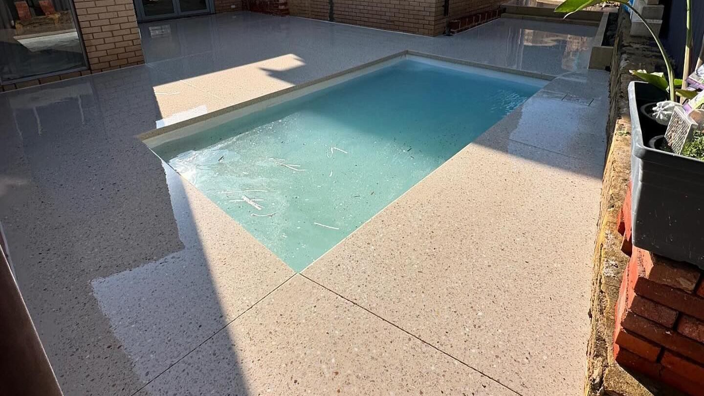 swimming pool in the backyard in a Perth home with honed concrete pool surrounds.