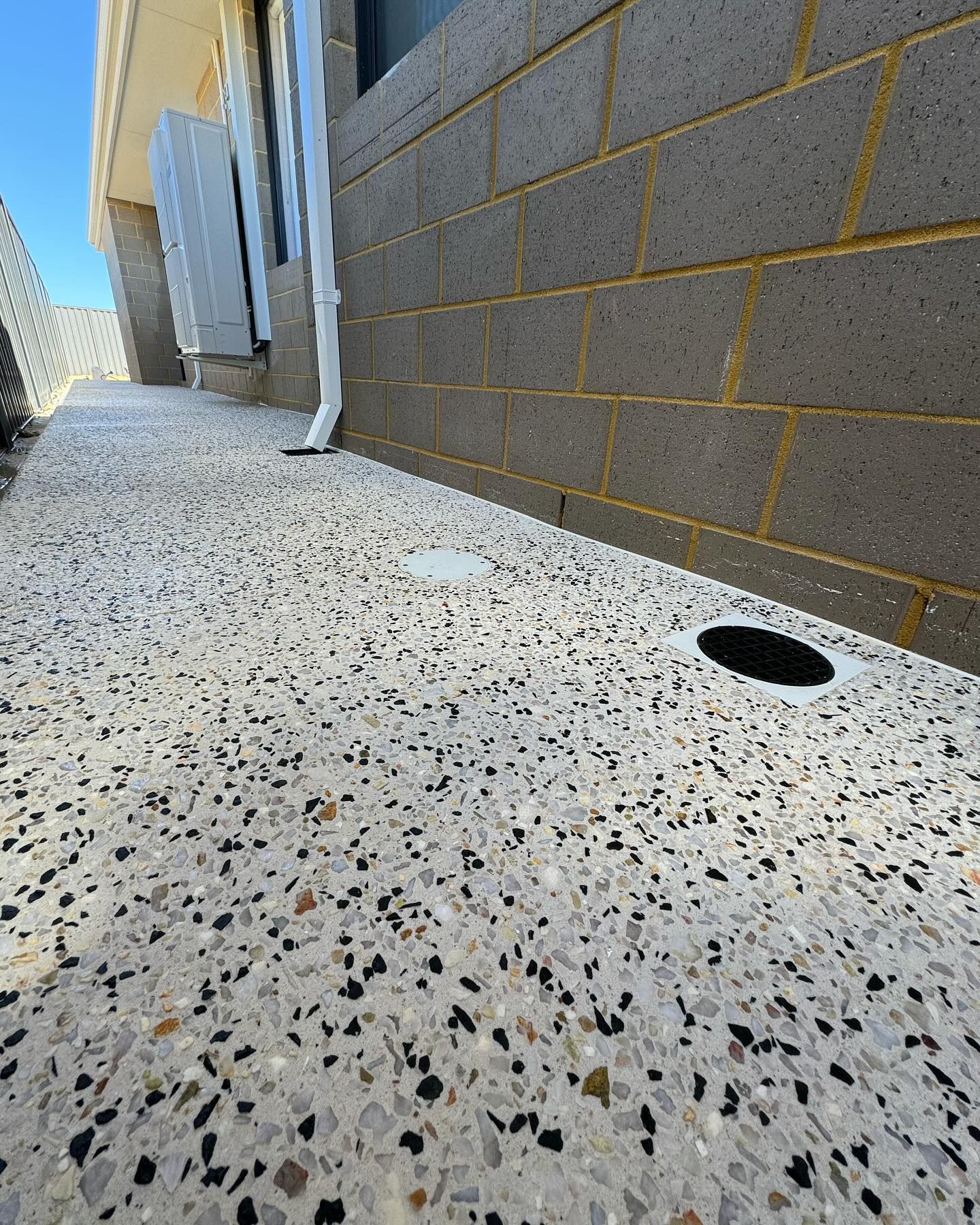 Exposed aggregate path close up of kajaani white mix and drainage insert within the concrete