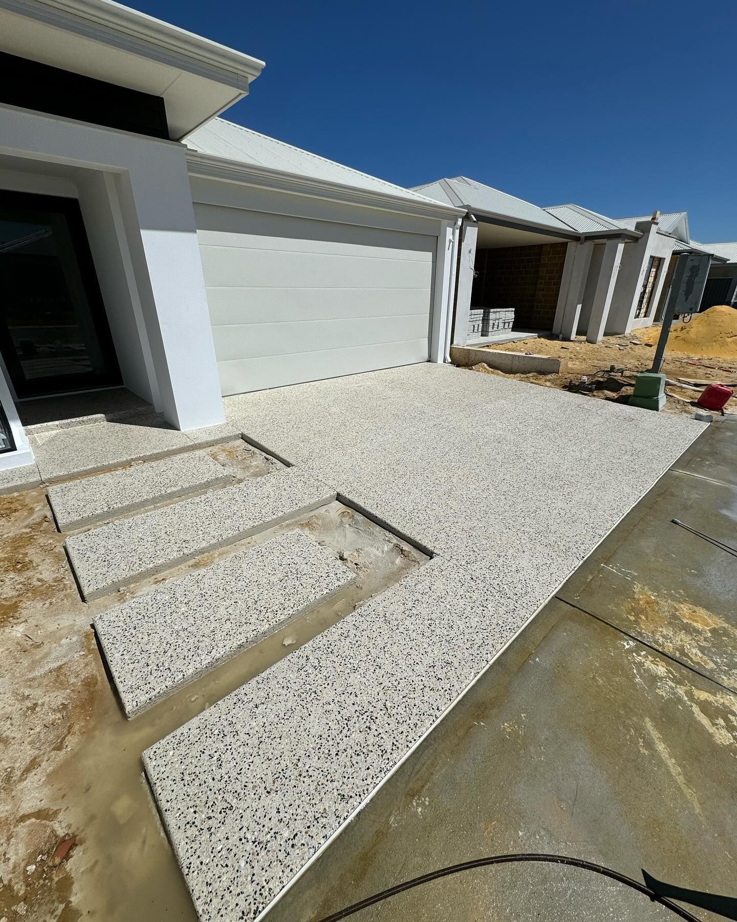 A concrete walkway is being built in front of a house.