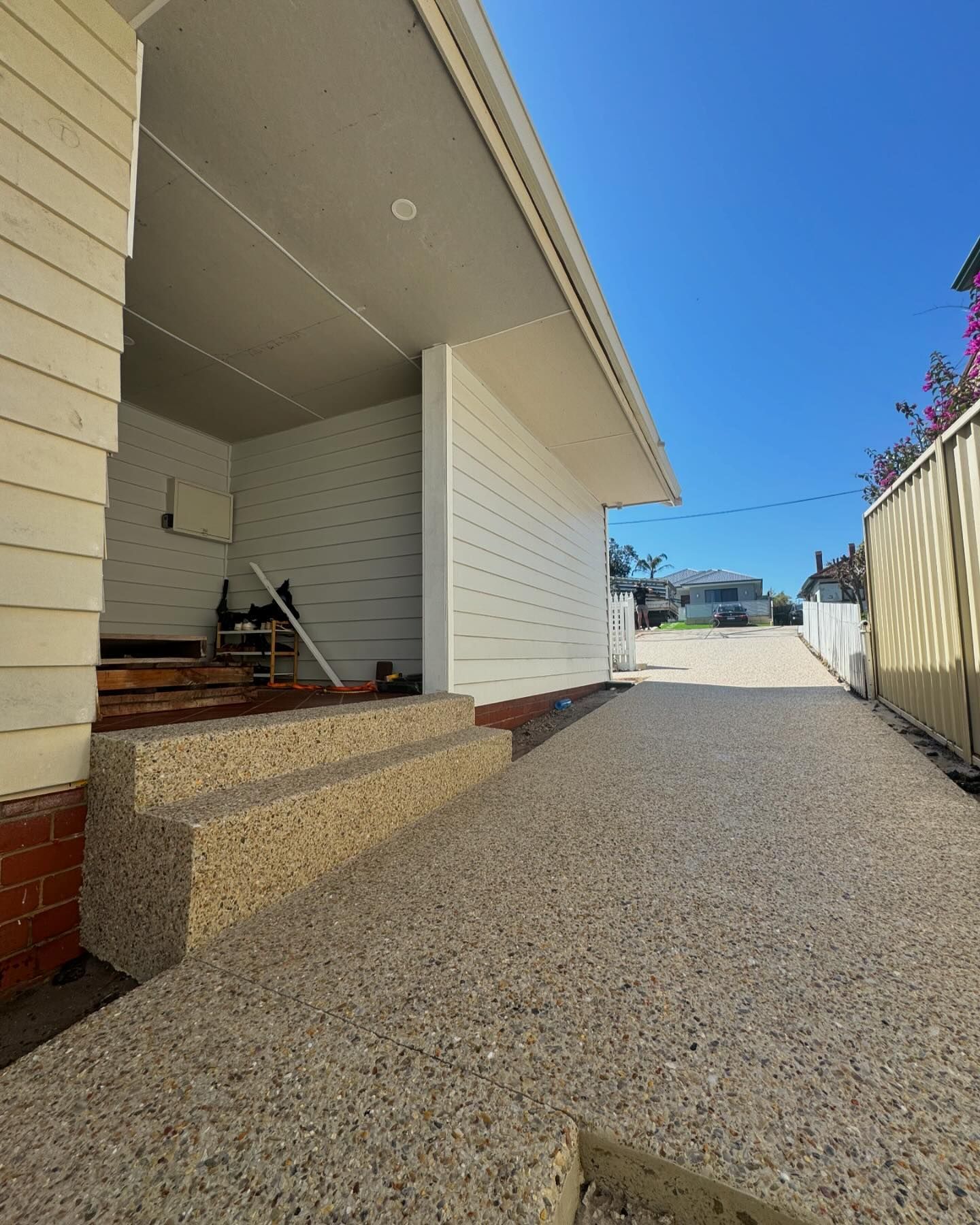 A white house with exposed aggregate stairs leading up to it