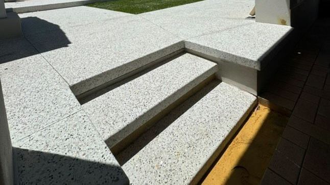 A close up of a set of exposed aggregate stairs leading out to Perth homes front yard.