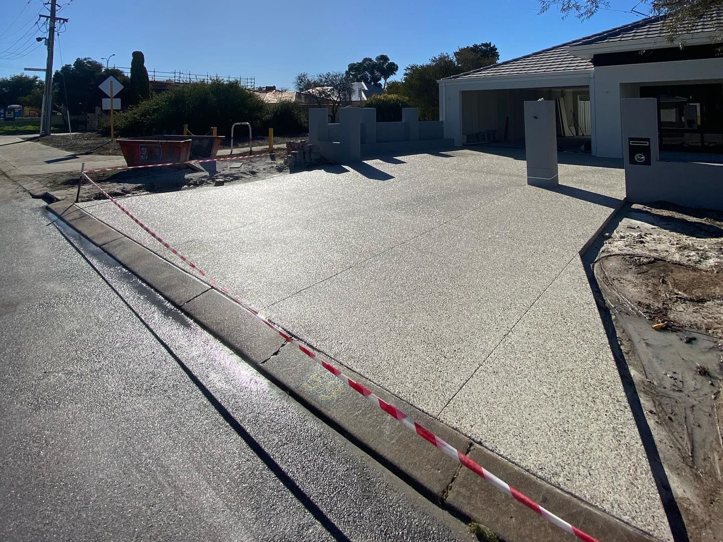 A concrete driveway has been built in front of a new house