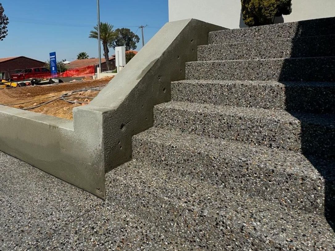 Exposed aggregate concrete stairs connected to the driveway and front door for a Perth home