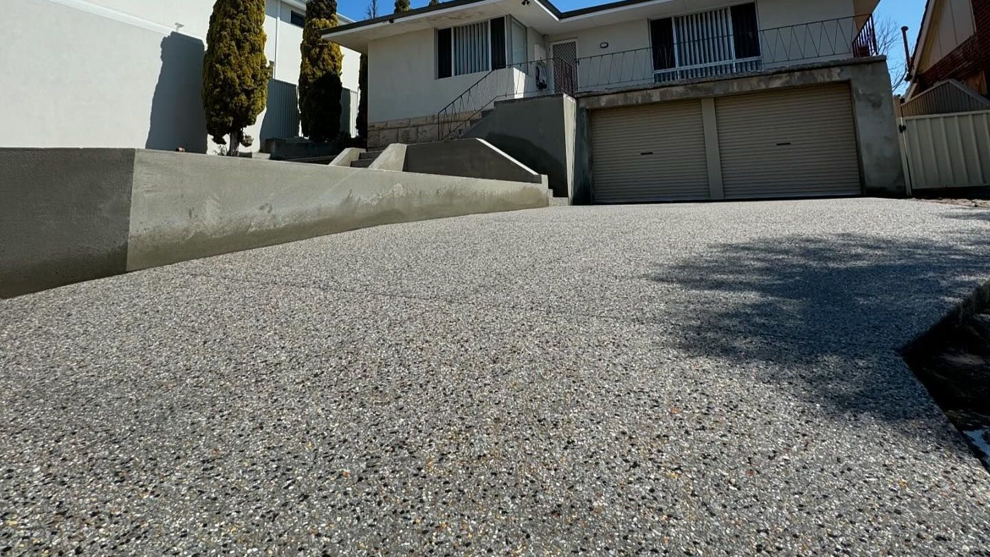 two storey house with retaining wall and exposed aggregate driveway