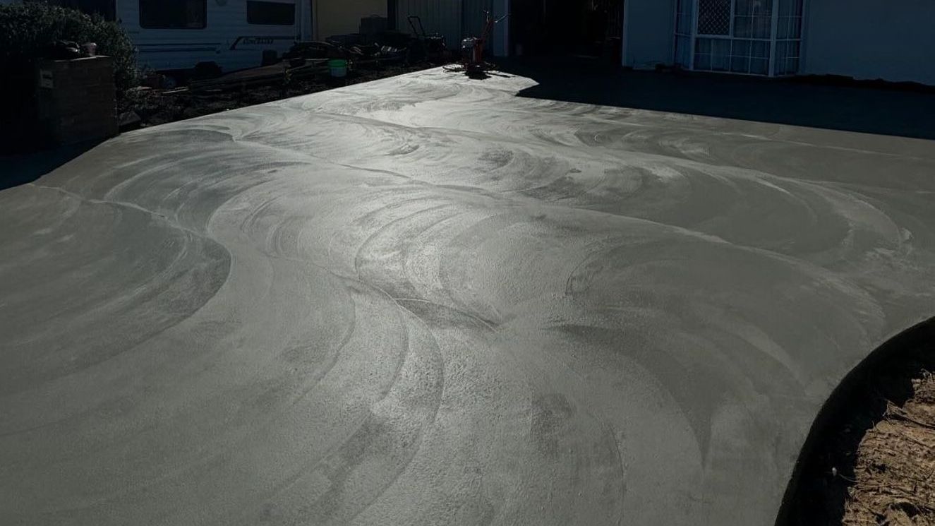 Smooth Grey Concrete Driveway with house in background