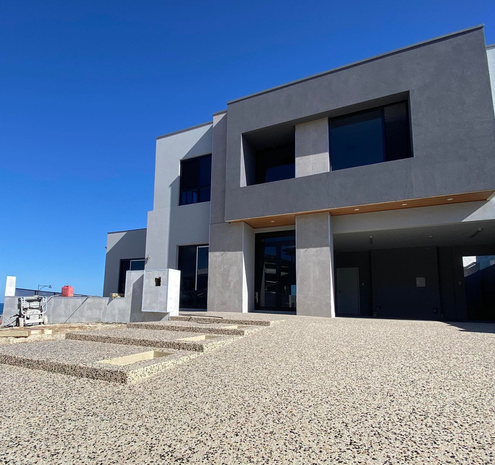 large two storey house with exposed aggregate driveway and inbuilt stairs in the driveway leading to the front door