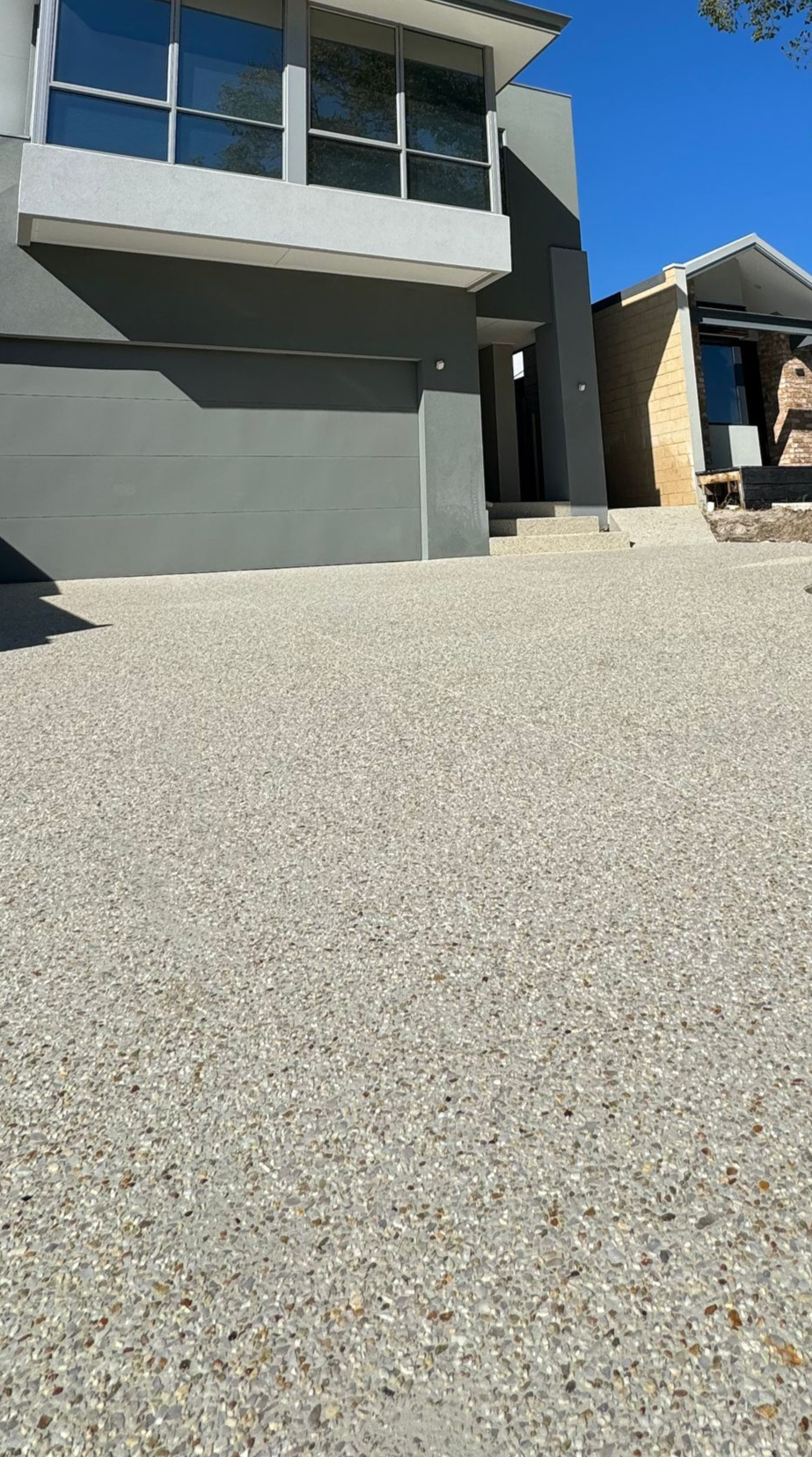 Exposed aggregate driveway to compliment modern house front.