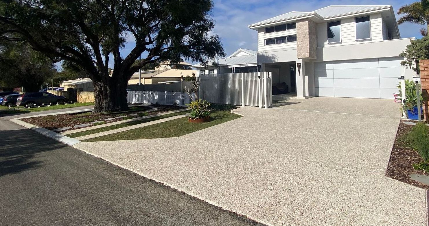 Coral Exposed aggregate concrete driveway in front of a two-story home in Perth.