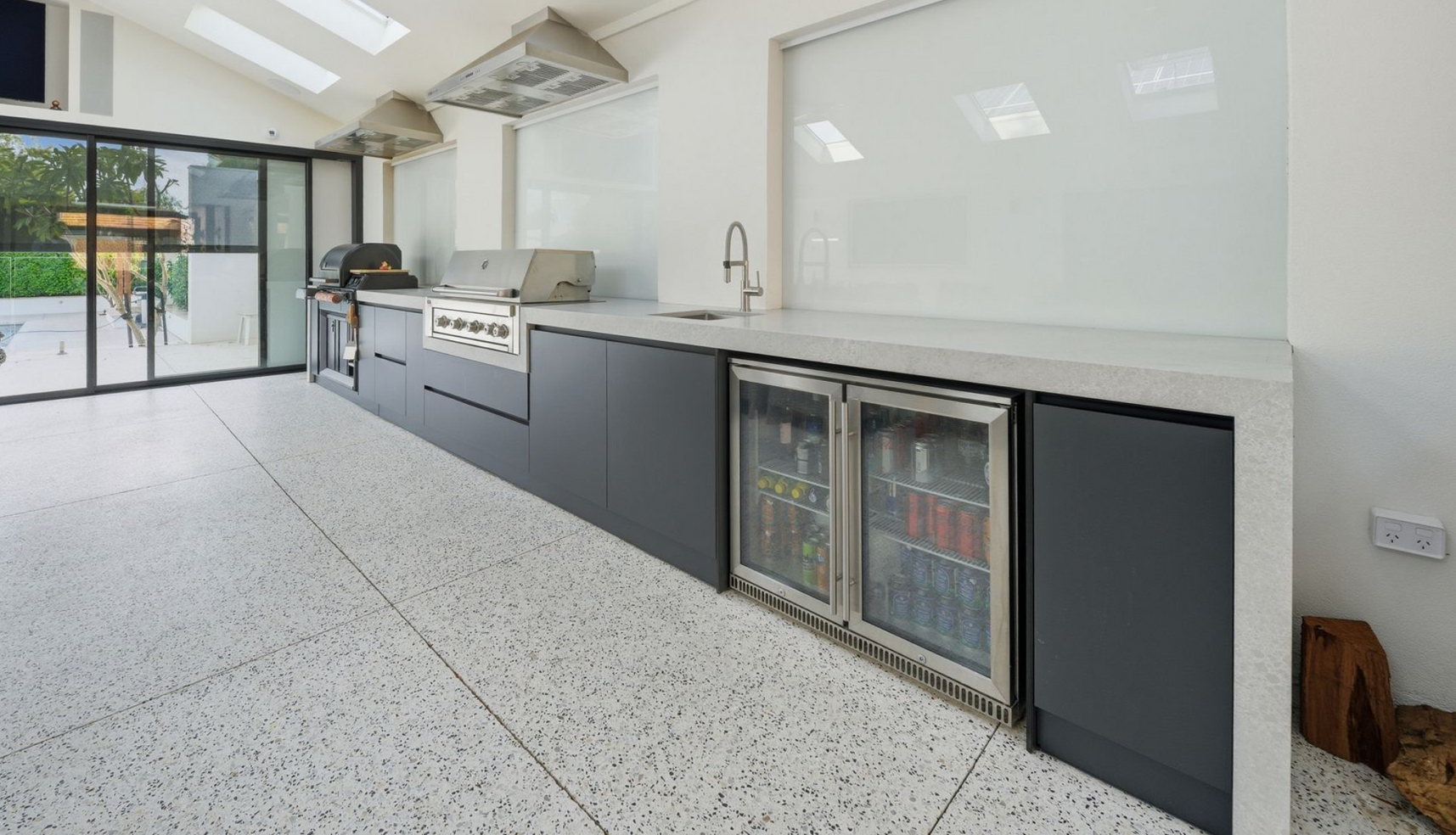 Honed concrete patio area with outdoor kitchen.