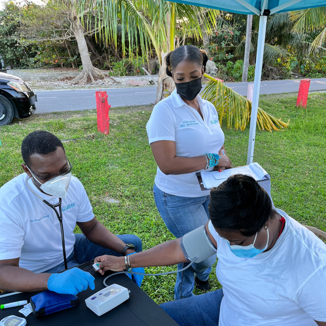 Photos of Dr. Bowleg and Mrs. Bowleg Helping Patients