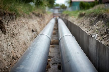 A row of pipes are being installed in a trench.